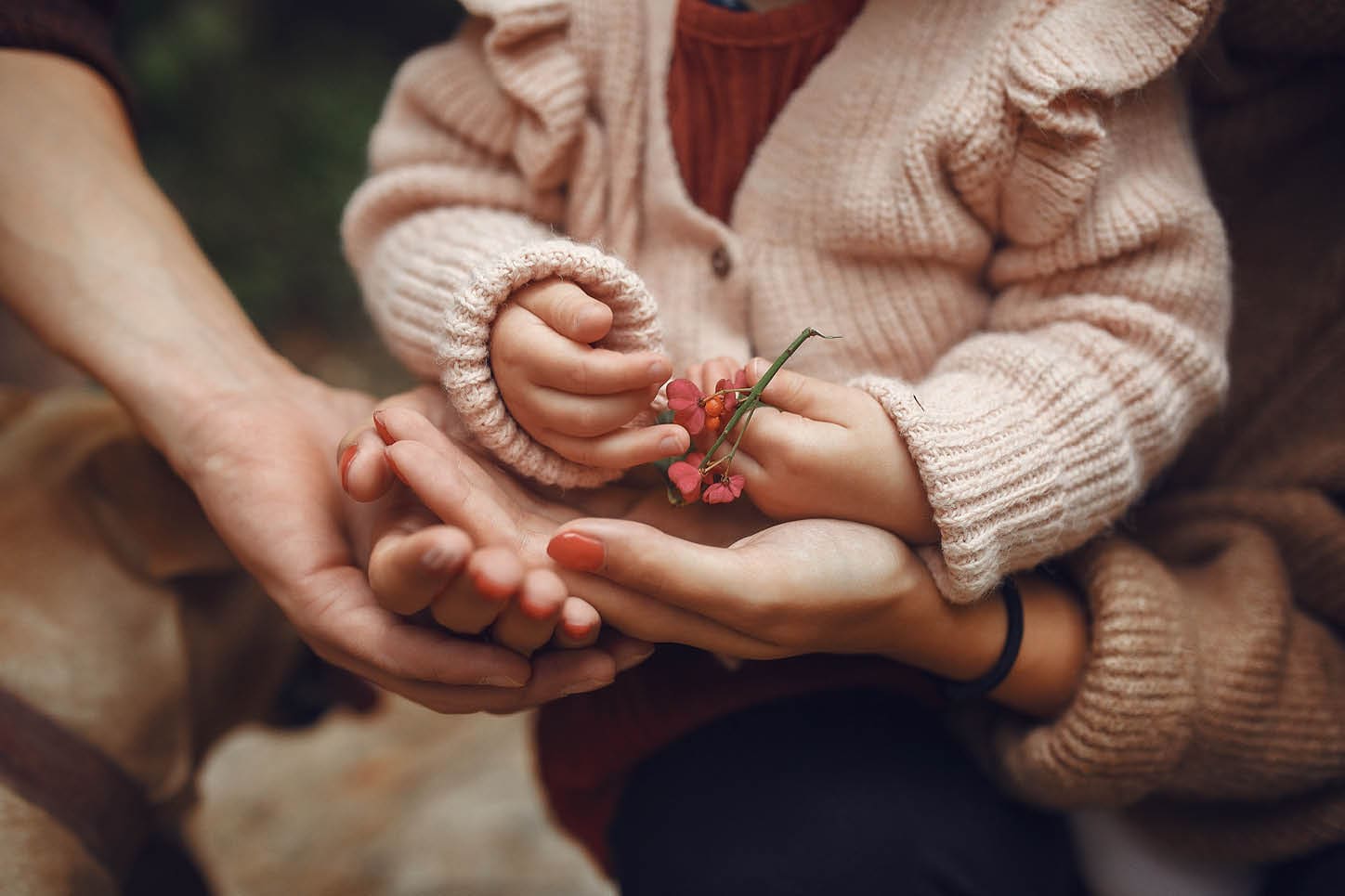 Family with cute little daughter. Father in a brown sweater. Family in a autumn field